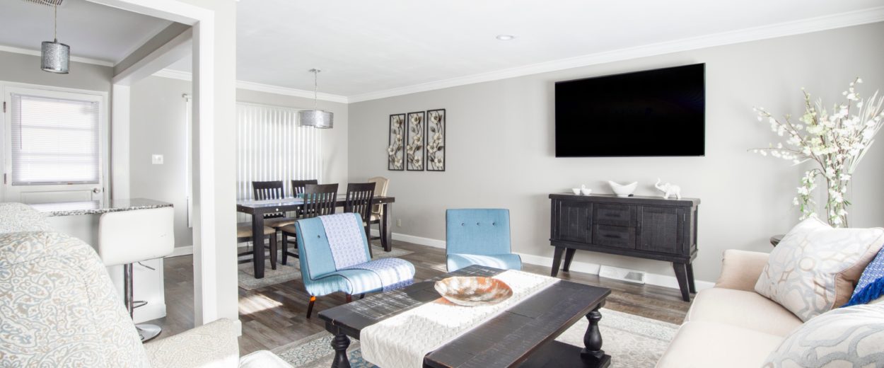 light living room with chairs, coffee table and a TV